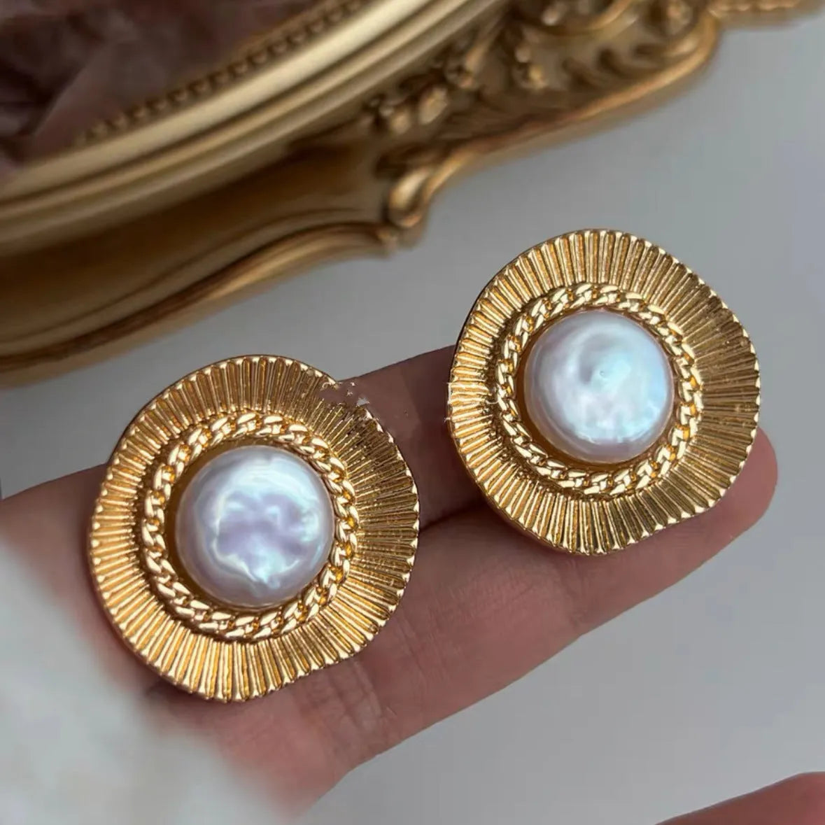 A pair of round gold-coloured retro earrings for women with a simple design.