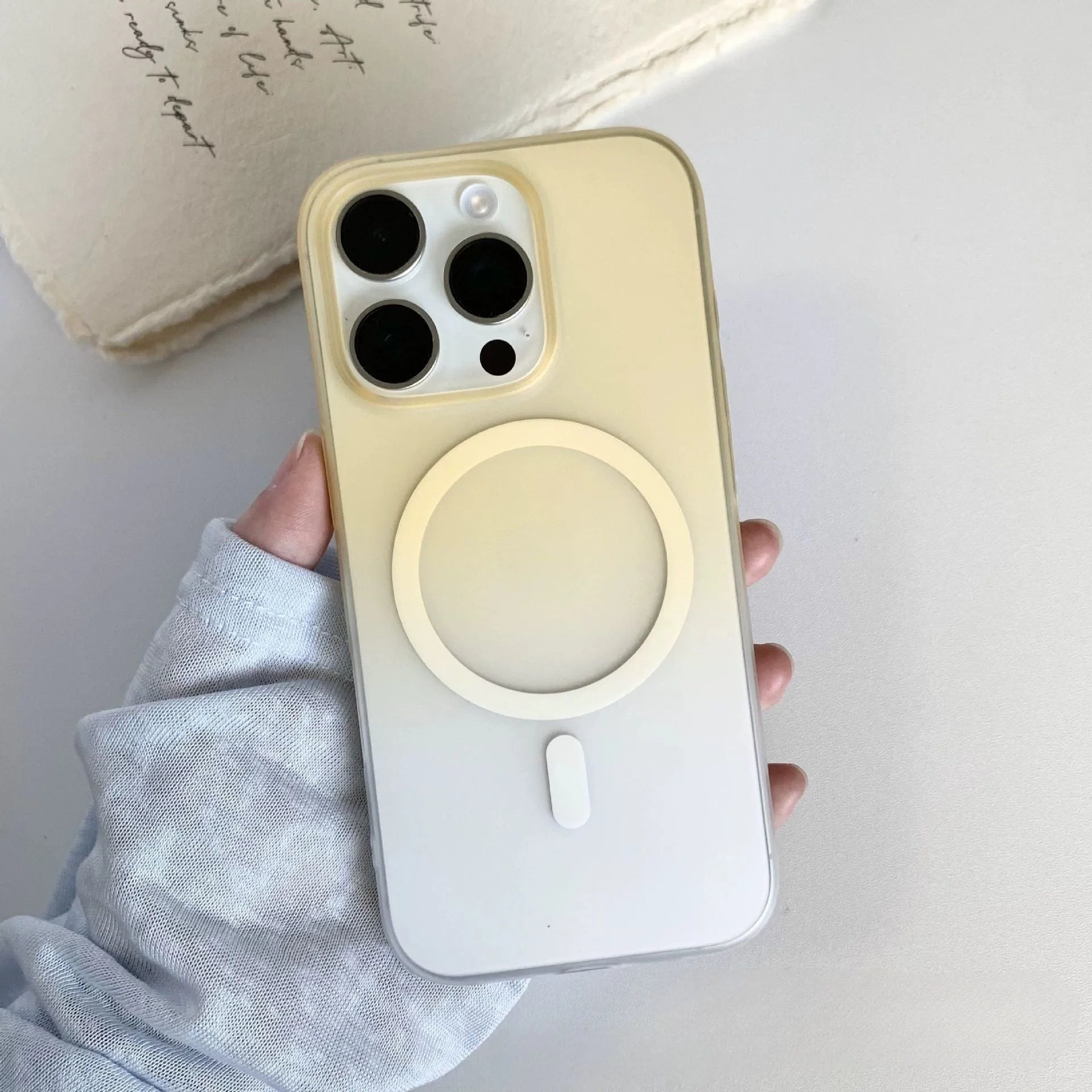 Gradient frosted magnetic suction case for iPhone on a table, showing ultra-thin profile and colour blend.