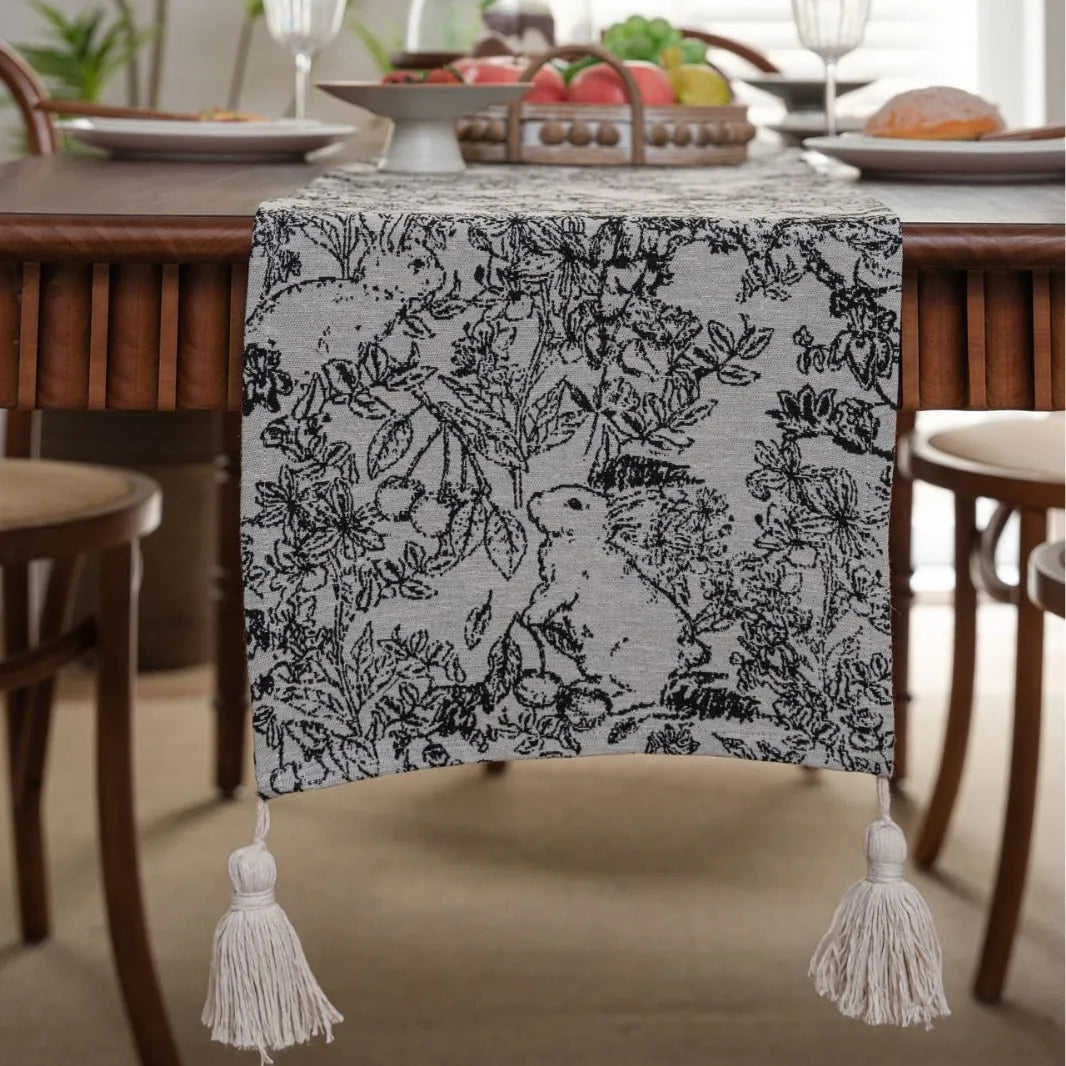 American-style beige jacquard table runner with floral pattern and long tassels on a dining table.