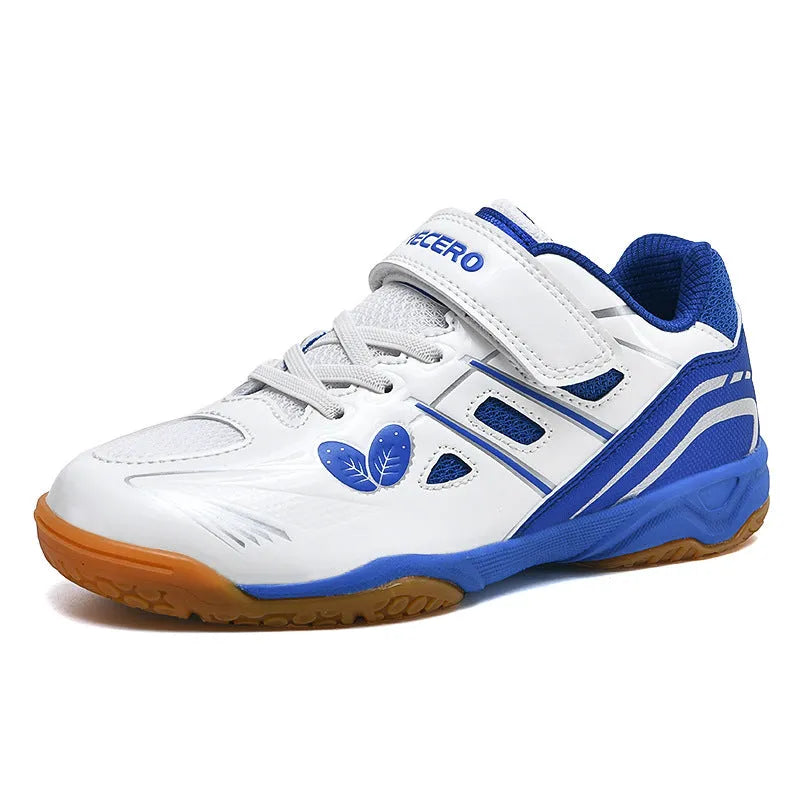 White and blue low-top badminton shoes with a ribbed sole and round toe on a hard court surface.