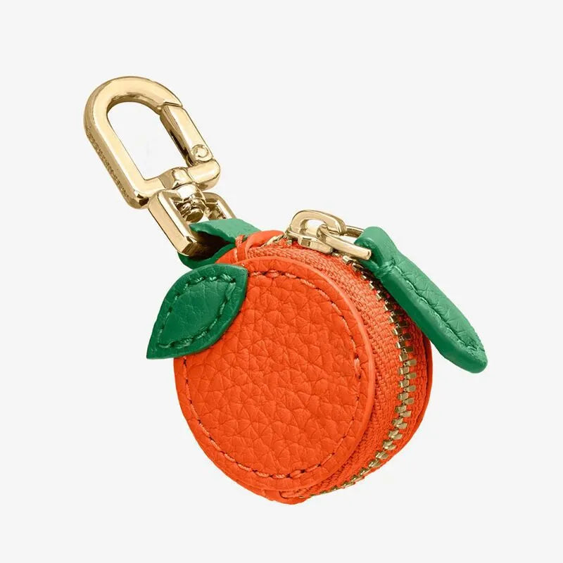 Mini solid colour PU leather coin purse keychain in cherry red, blueberry blue, or orange.