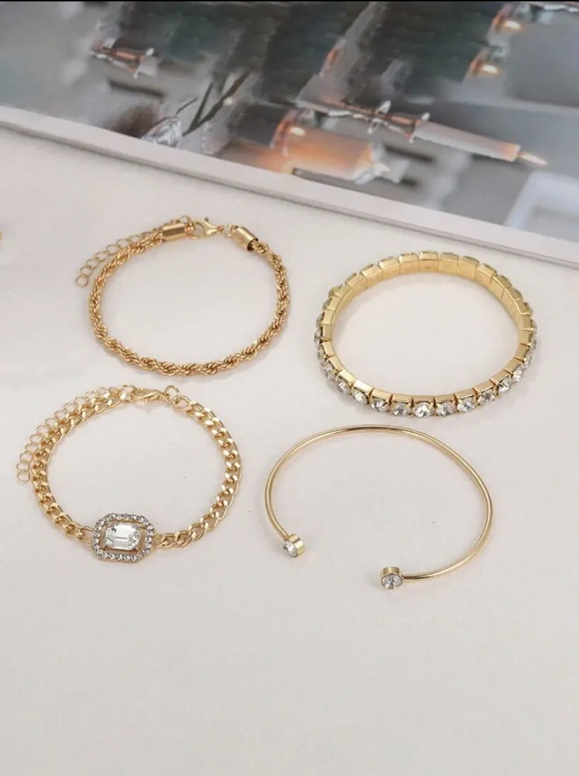 Four geometric bracelets with square diamond motifs on metal chains in gold colour