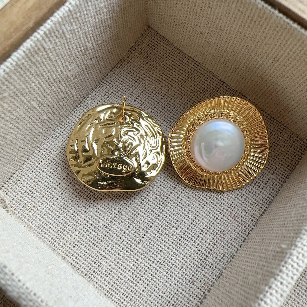 A pair of round gold-coloured retro earrings for women with a simple design.