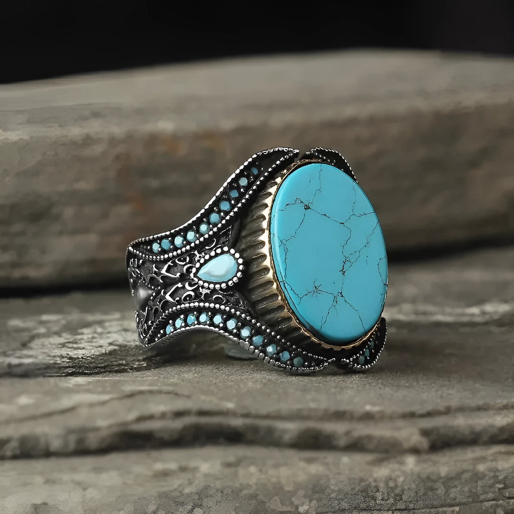 Men's antique silver alloy ring with a round band and a central turquoise stone on a finger.