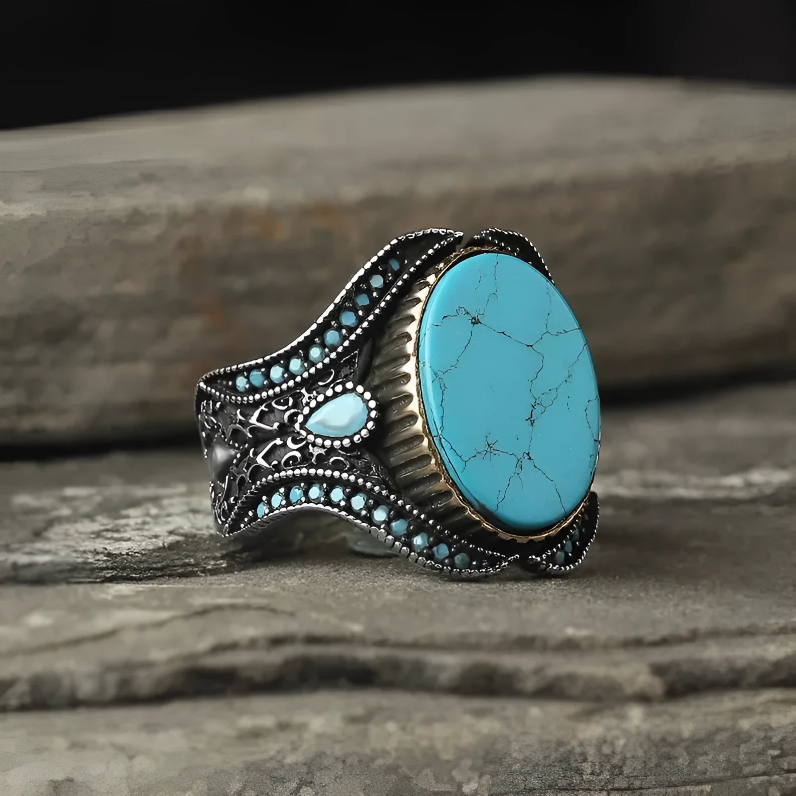 Men's antique silver alloy ring with a round band and a central turquoise stone on a finger.