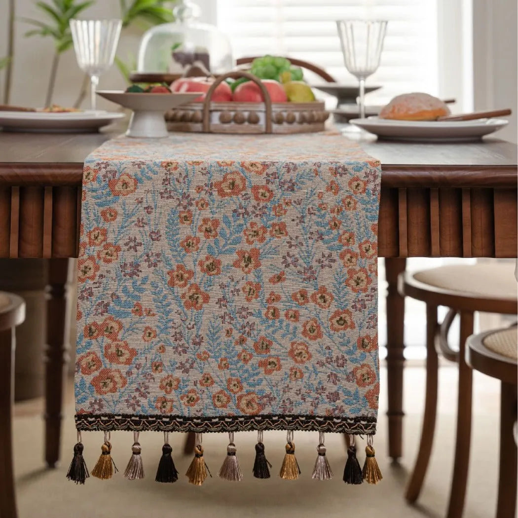 American-style beige jacquard table runner with floral pattern and long tassels on a dining table.