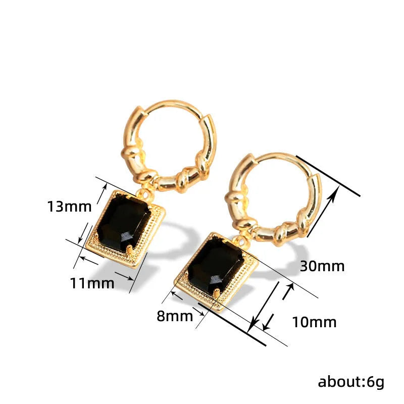 A pair of geometric copper earrings with black zircon stones in a quadrilateral design.