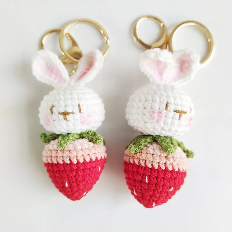 White hand-woven wire pendant of a cartoon rabbit with strawberry details, shown with an attachment key.
