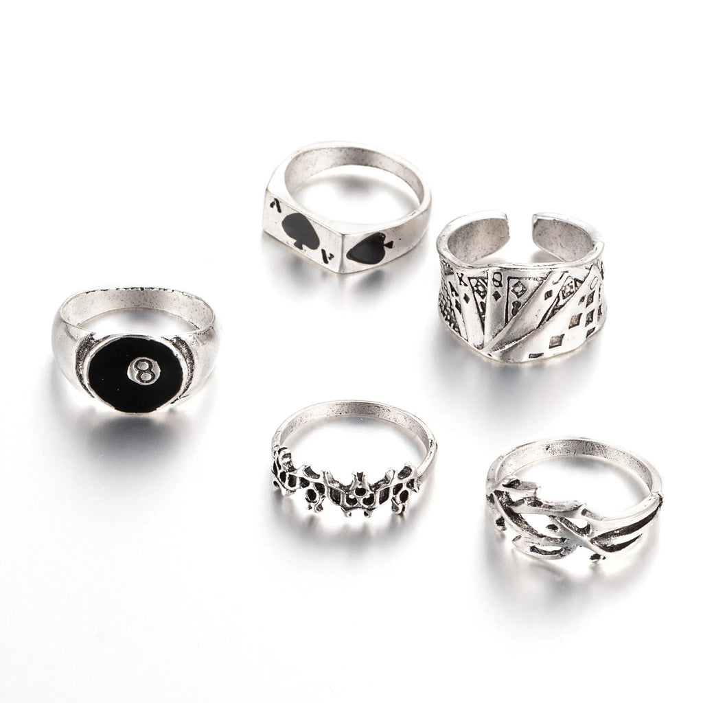 Black alloy ring with a detailed retro spade card design on a finger.