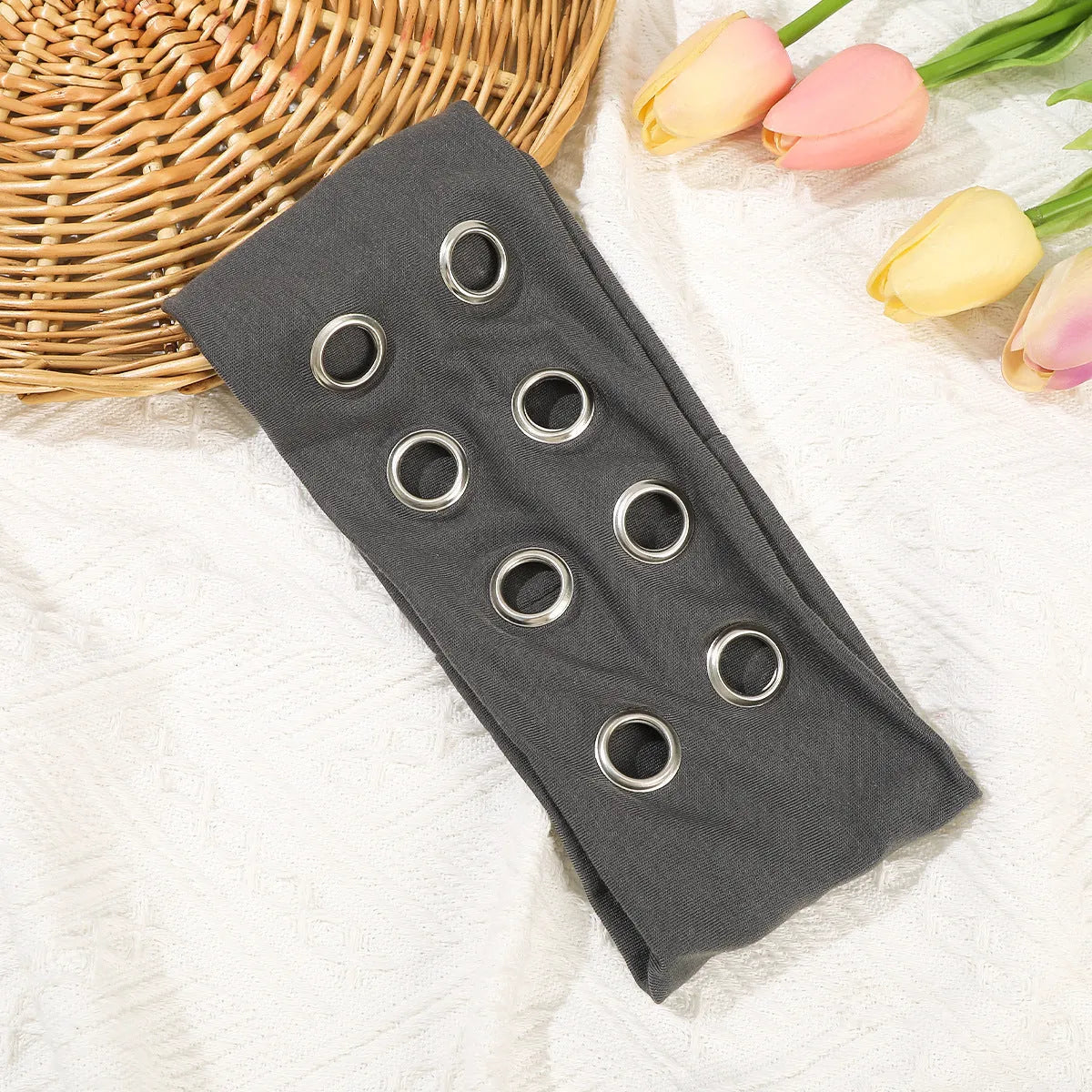 A black polyester exercise hair band with a hollow metal decorative centrepiece.