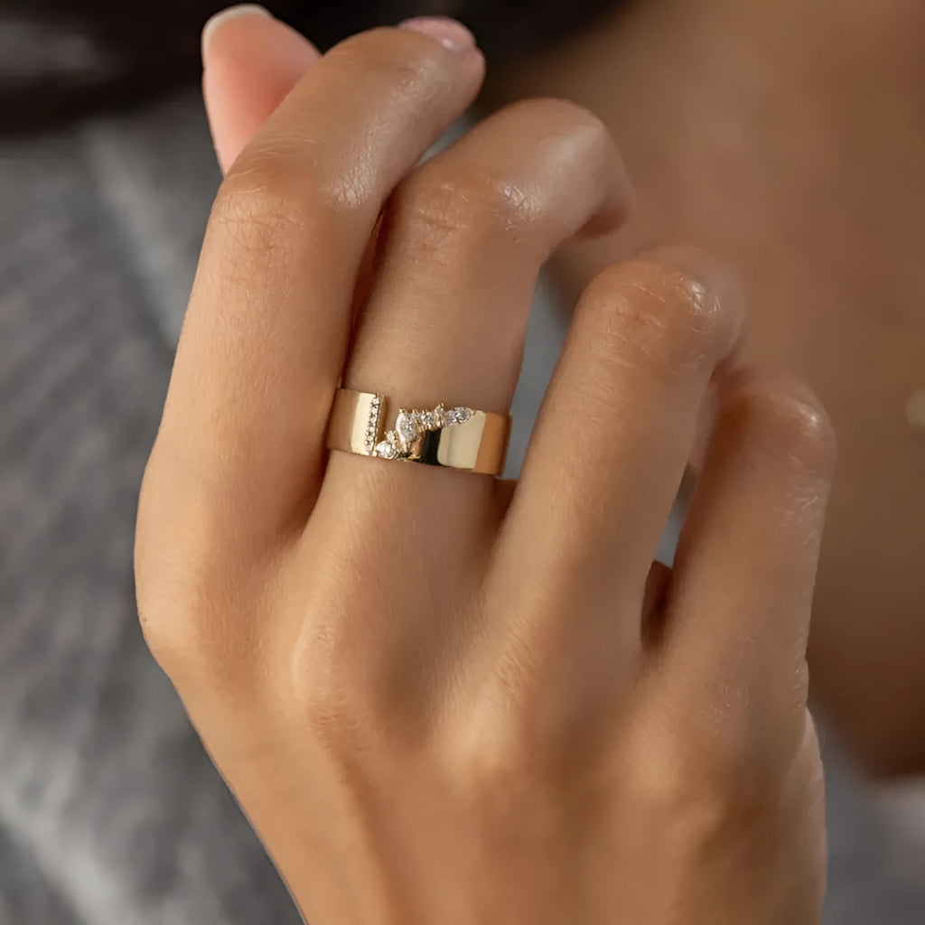 Gold electroplated copper ring with shining zircon stones on a finger.