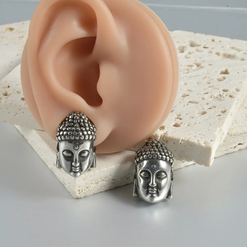 Stainless steel hollow skull Buddha earrings in hip hop style with geometric shape.