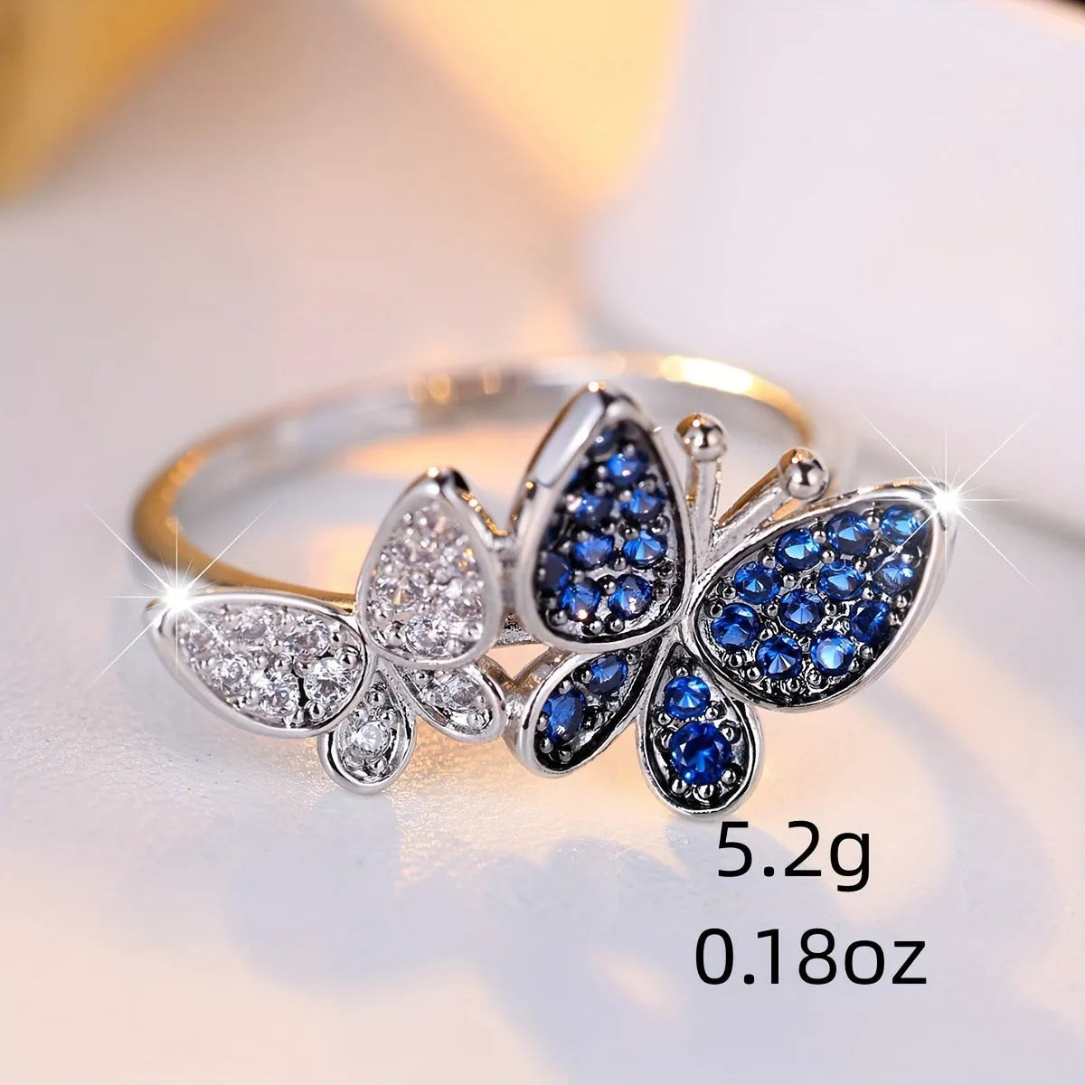 A blue and white electroplated butterfly ring for women, made from copper, shown in UK size 10.