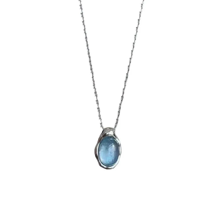 Geometric navy blue and platinum water drop pendant necklace on an adjustable copper cross chain.