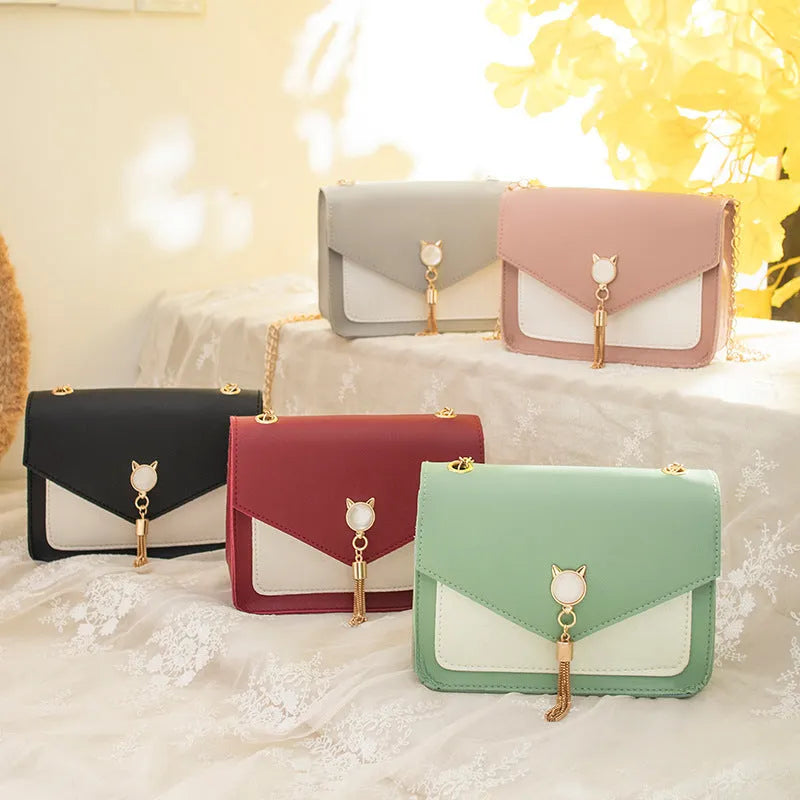 Small square PU leather crossbody bag with cat tassel decoration, magnetic flap, and adjustable chain strap in black