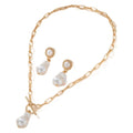 Gold tone baroque pearl pendant necklace and matching ear stud set on white background