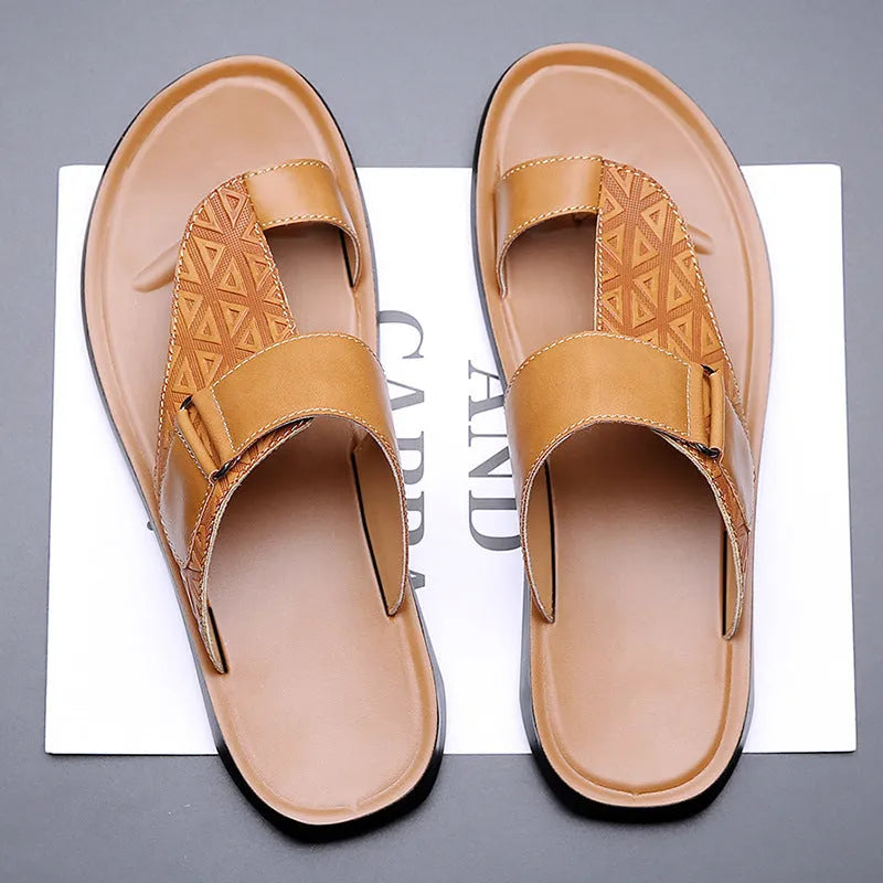 Men's white cowhide open-toe beach slippers with a rubber sole on a sandy background.