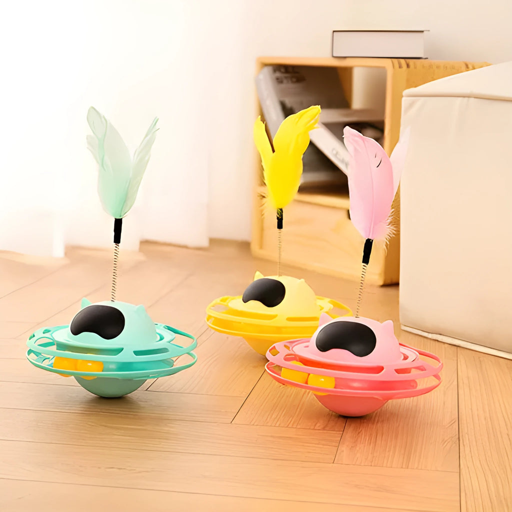 Pink cat tumbler turntable toy with a colourful baton on a flat surface.