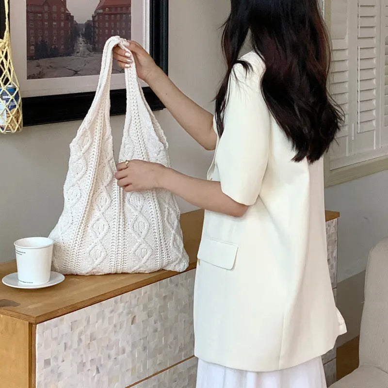 Retro hollow knitted woolen women's shoulder tote bag in a solid colour, showing double straps and large capacity.