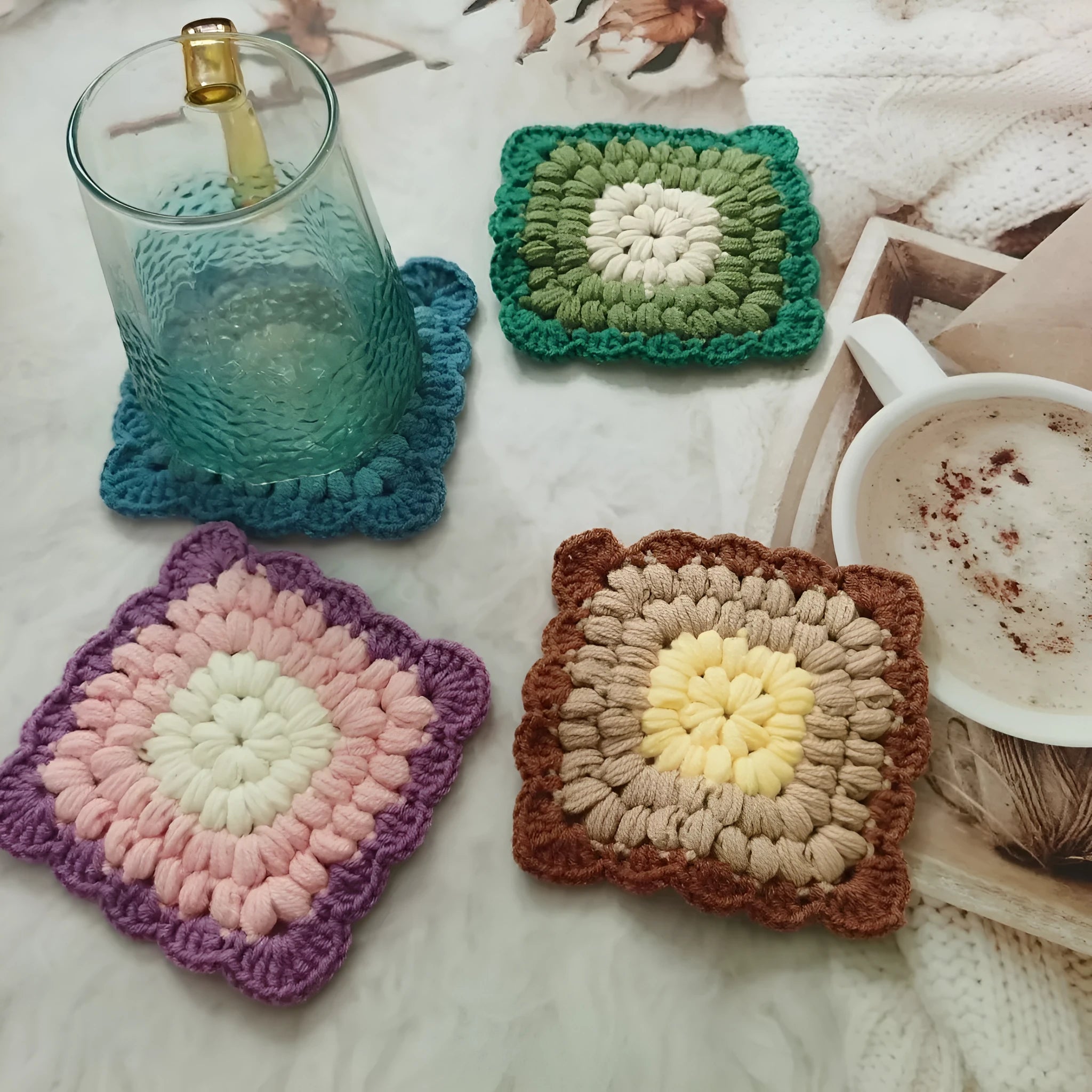 Crocheted wool cup placemat with grandmother lattice pattern in a choice of four colours.