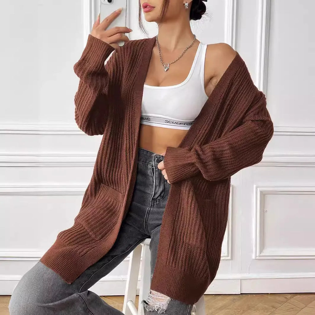 Women's dark green double pocket cardigan sweater with a V-neck and long sleeves laid flat.