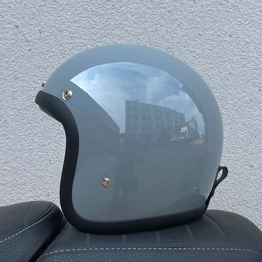 Retro-style open-face motorcycle half helmet in fibreglass, shown in a cement grey colour on a white background.