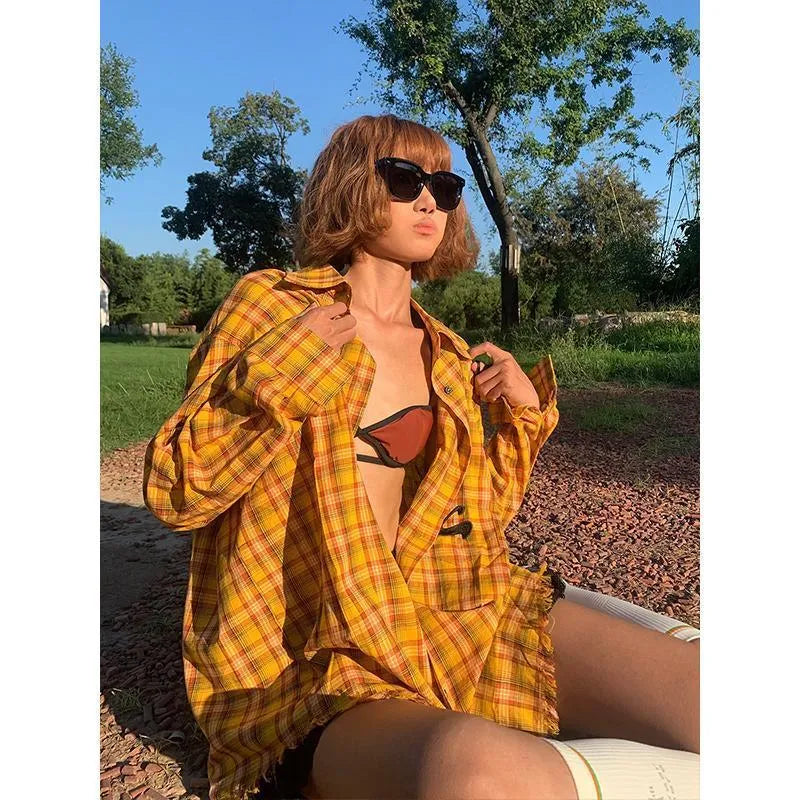 Yellow and black plaid shirt with a loose cardigan-style fit on a hanger.