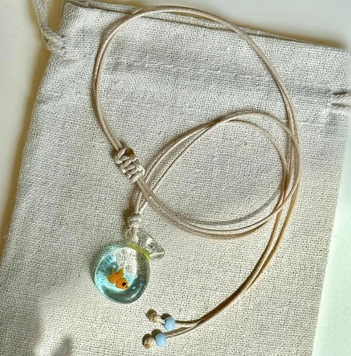 Women's pendant necklace with coloured glaze joker charm on a cotton and linen clavicle chain.