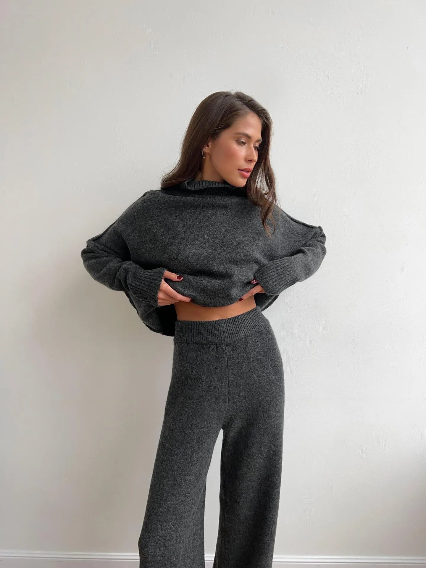 Women's dark grey acrylic knit two-piece suit with matching top and trousers.