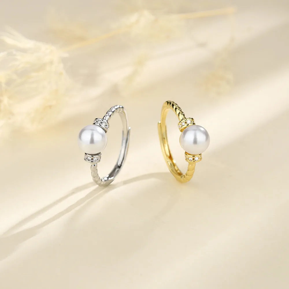 Adjustable antique twist copper ring with an inlaid pearl in gold colour.