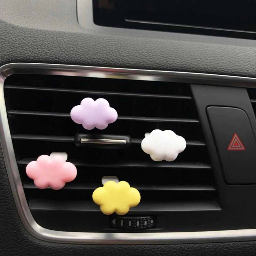Resin cartoon cloud car air freshener clip in assorted colours on a car vent.