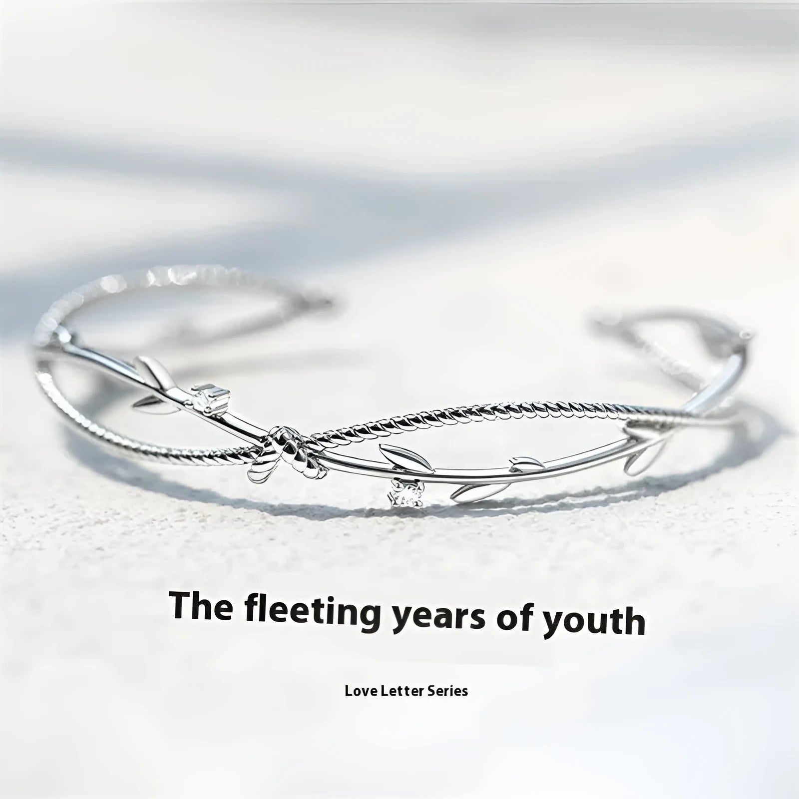White gold sprout branch bracelet with cross twisted design on a wrist.