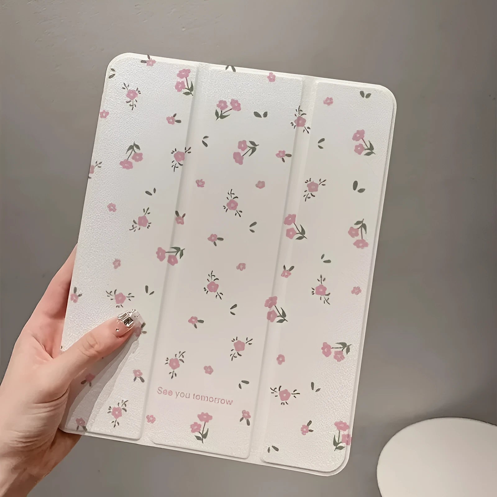 Transparent floral tri-fold iPad protective case showing magnetic stand function and cartoon design