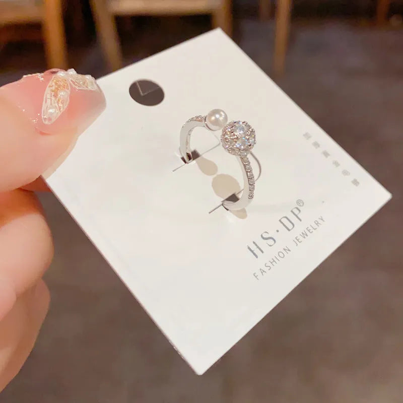 Open-end ring with round zircon stones and pearl accents in gold or silver plating