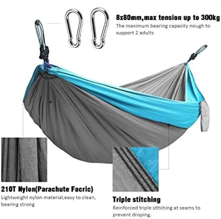 Blue parachute nylon camping hammock hung between two trees showing its full 270cm length.