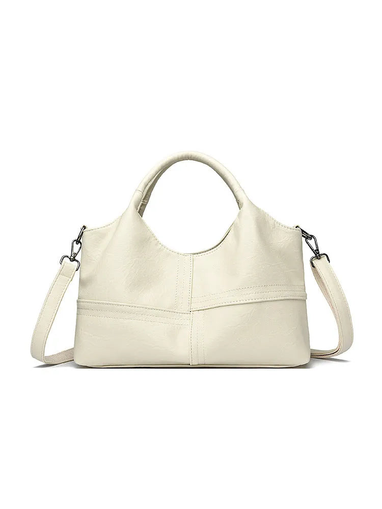 Soft leather crossbody handbag in black, bucket shape with single shoulder strap, lightweight design for women