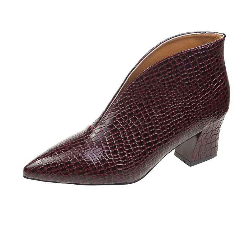 Women's black V-cut pointed toe Martin boots with a chunky heel on a rubber sole