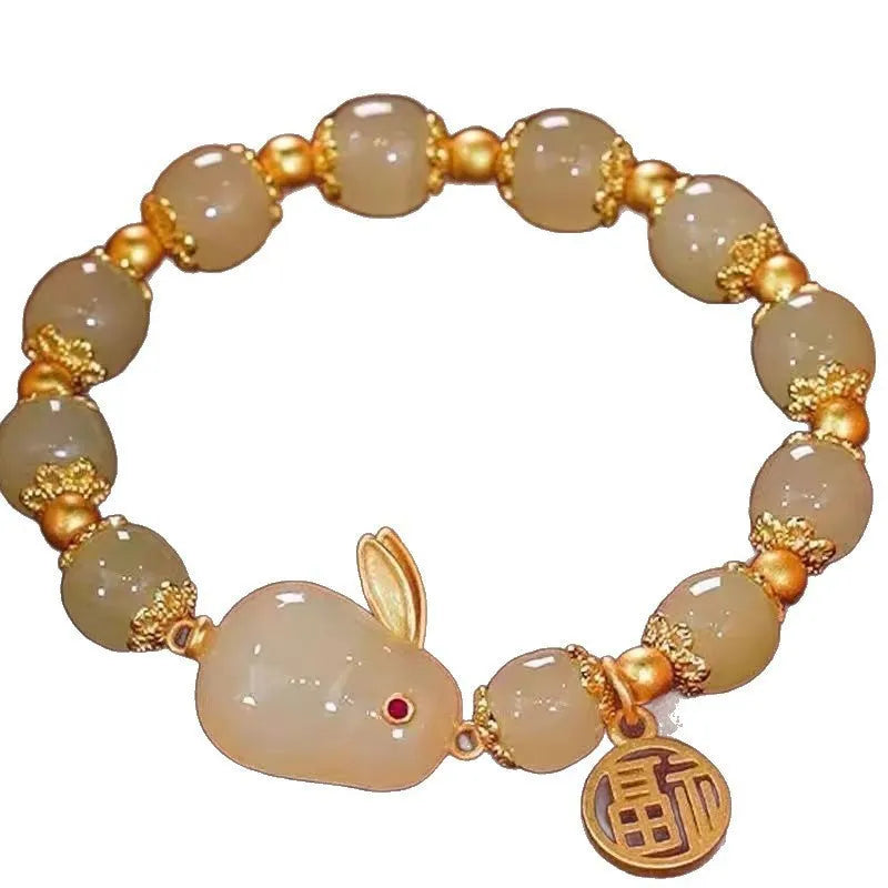 Handmade bracelet with glass beads, a rabbit charm, and a silver-coloured peace buckle on a white background.