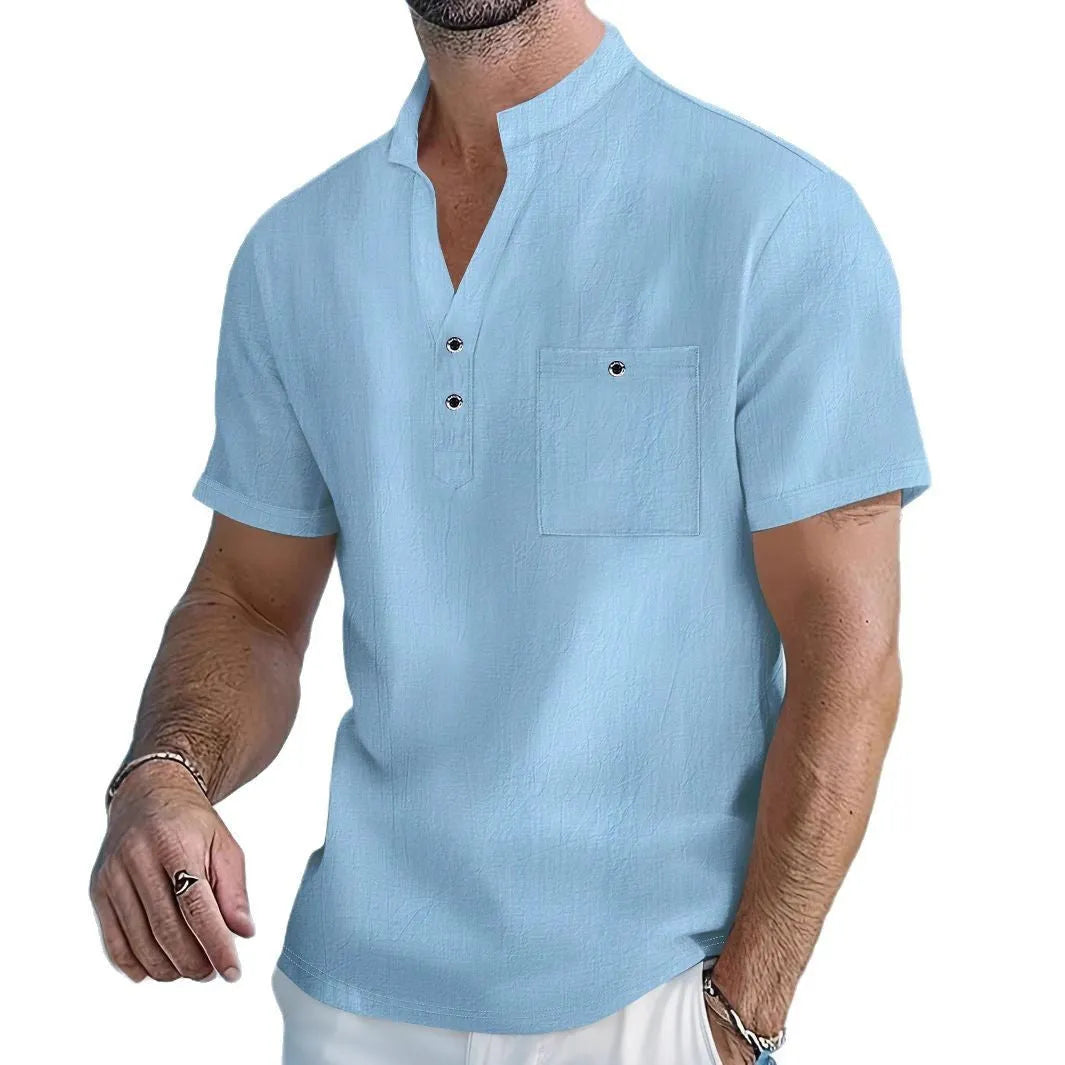 A man wearing a light blue linen stand collar short-sleeve shirt, showing the loose fit and structured neckline.