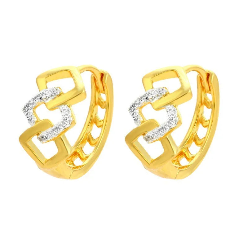 A pair of gold-coloured geometric drop earrings with a hollow out design on a plain background.