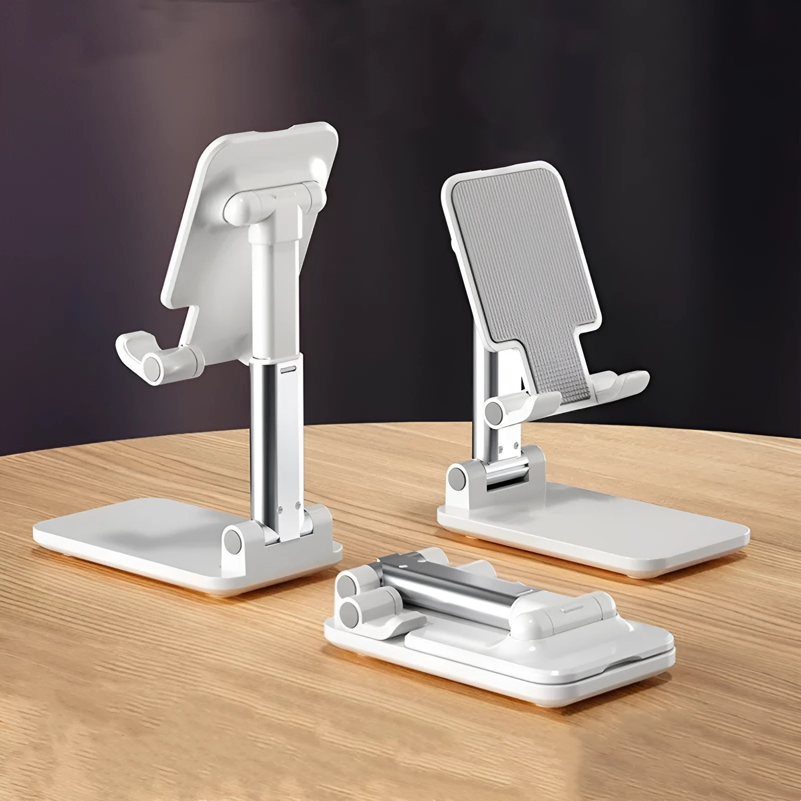 Folding telescopic mobile phone bracket in blue on a desktop, holding a smartphone securely with its silicone pad.