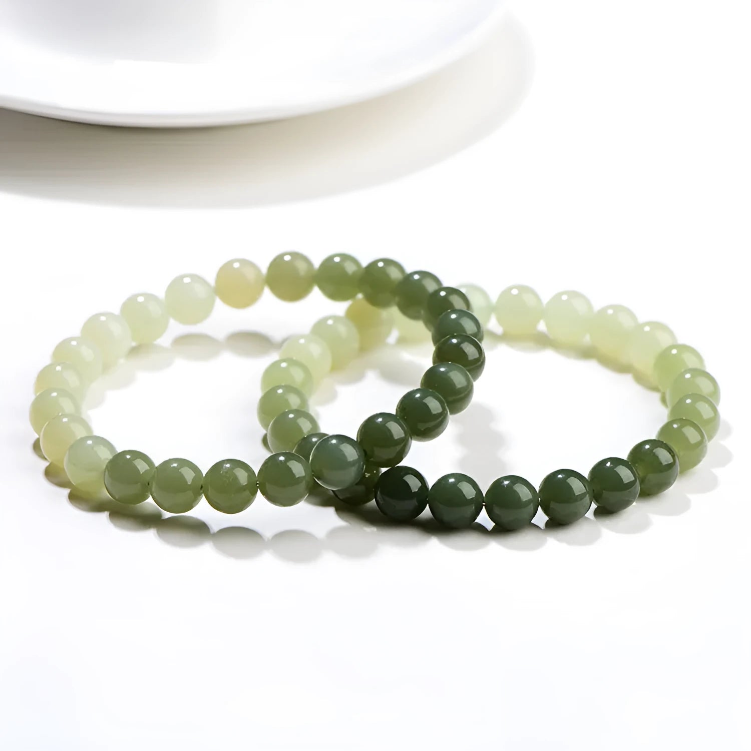 Natural clear water Hetian jade bracelet showing gradient colour on round beads and barrel beads.