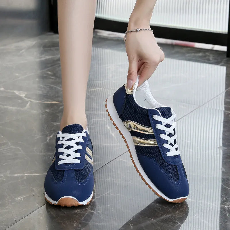 Blue women's casual tennis shoes with cross shoulder straps and a lace-up front on a rubber sole.