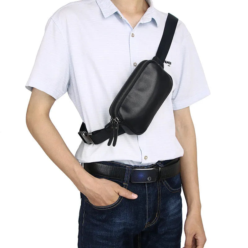 Men's small black leather crossbody bag showing compact size and crossbody strap.