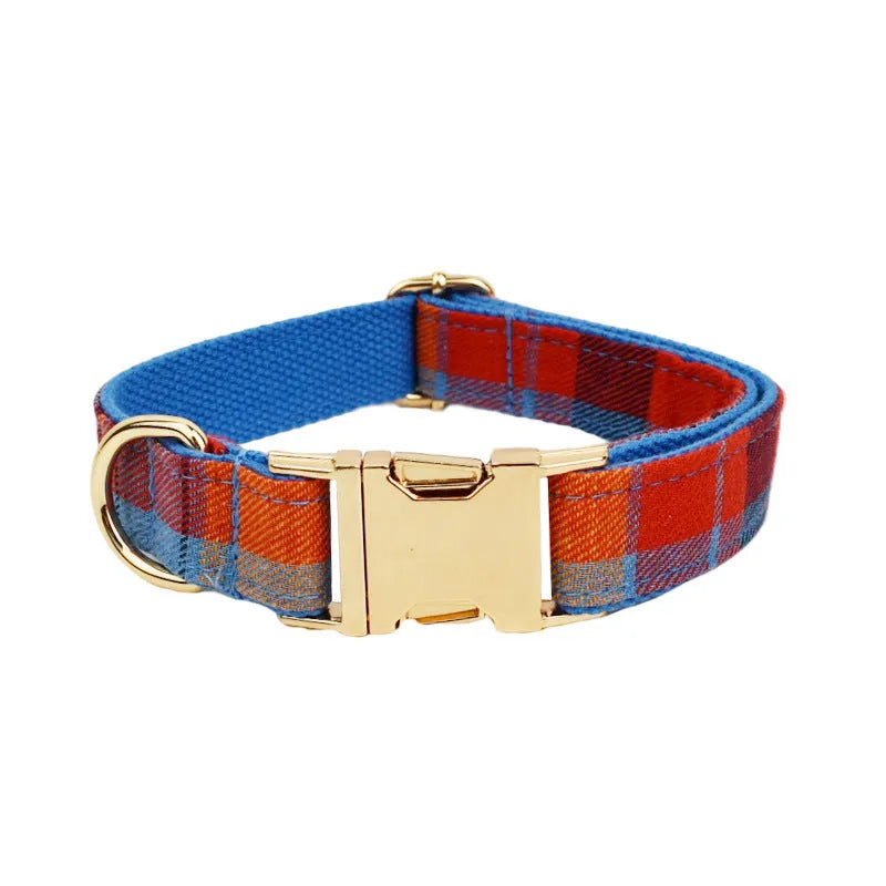 Blue background velvet plaid dog collar and matching hand holding leash on a white surface.