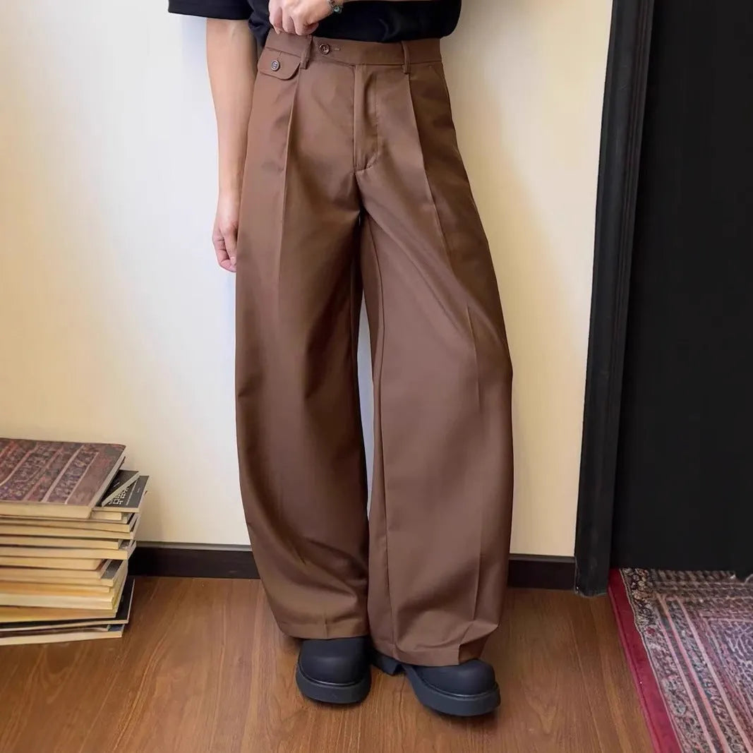 Man wearing solid colour straight-leg casual suit trousers with a loose wide-leg draping fit.