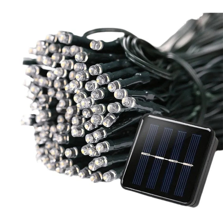 Solar outdoor LED colour light string with 22m 200 lights draped along a garden fence at dusk, showing warm white illumination and weatherproof construction