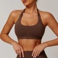 Women's black halter style sports bra with hollow cut and chest pads on a mannequin.