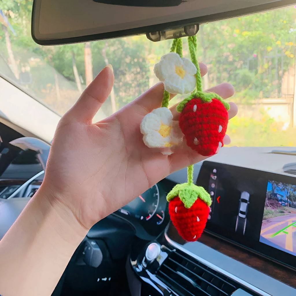 Handmade strawberry-shaped car pendant woven from cotton and hemp wool, hanging as a decorative accessory.