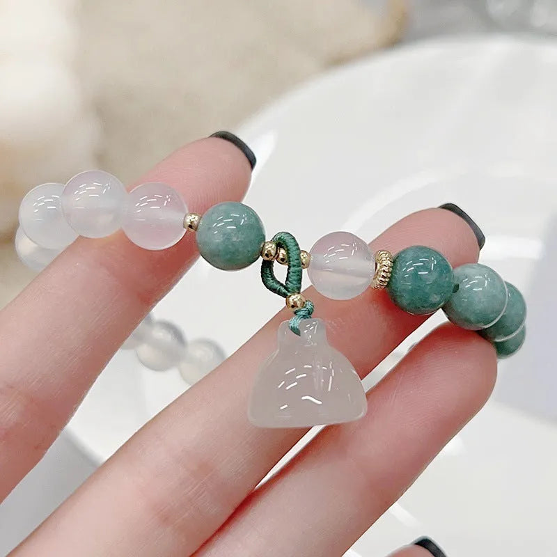 Close-up of a women's retro Chinese style agate lotus seedpod bracelet on an adjustable strap.
